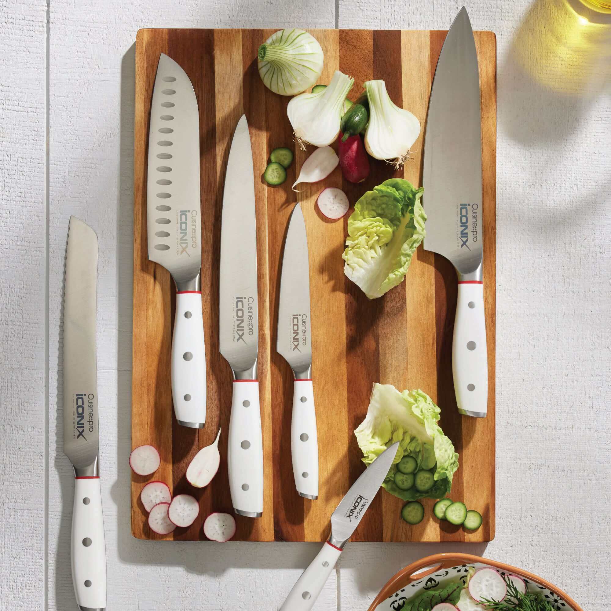 Cuisine::pro® iconiX™ Straub 7 piece knife block set made from German stainless steel with various knives placed on a wooden cutting board
