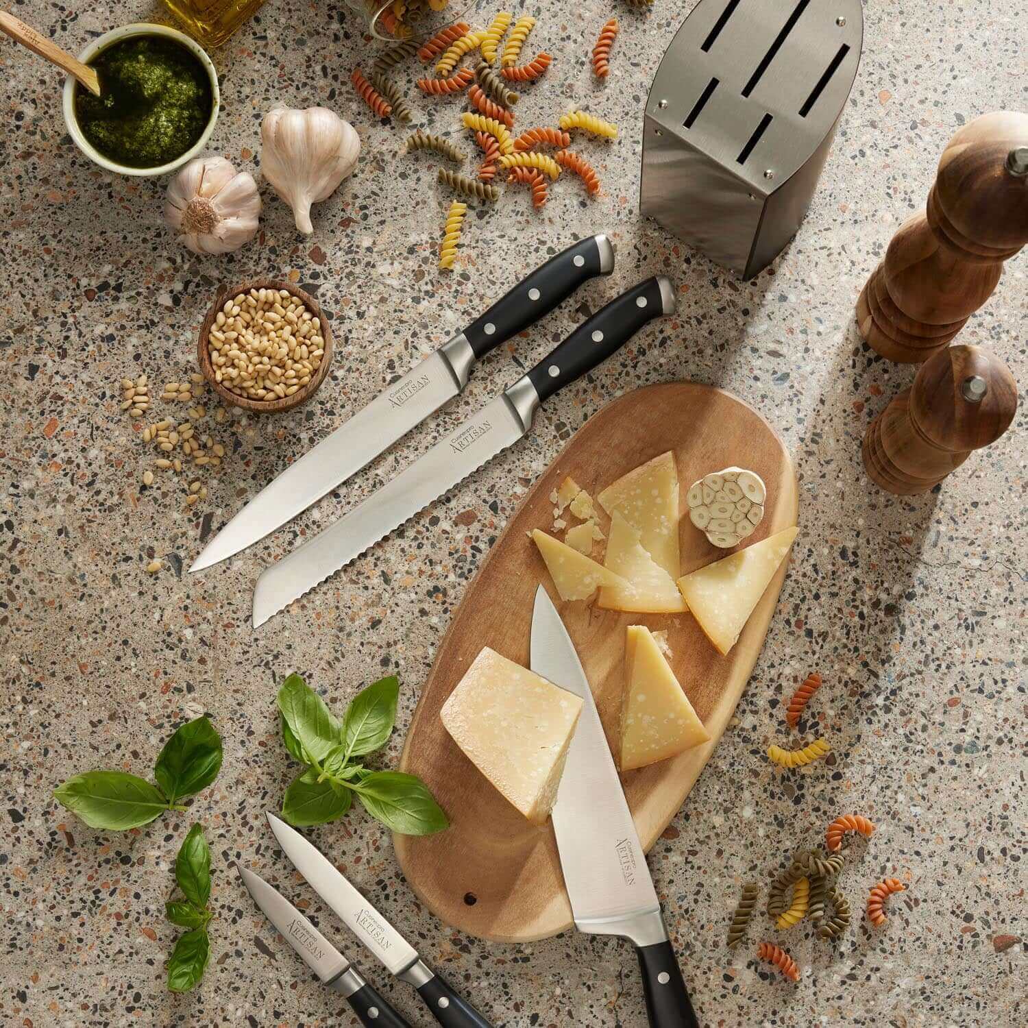 Cuisine::pro® ARTISAN™ Kyoto 6 Piece Knife Block set displayed with cheese, pesto ingredients, and herbs on a kitchen counter.